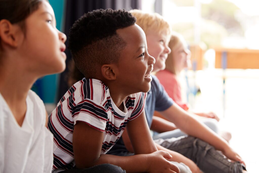 group of elementary school pupils sitting on floor